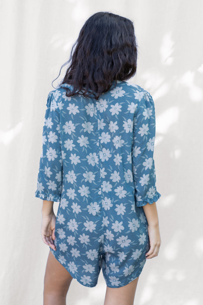 Floral Romper with small ruffle detail on the sleeve and a slight high low hem - Hawaiian Flower Print in Blue - Agave - Back View