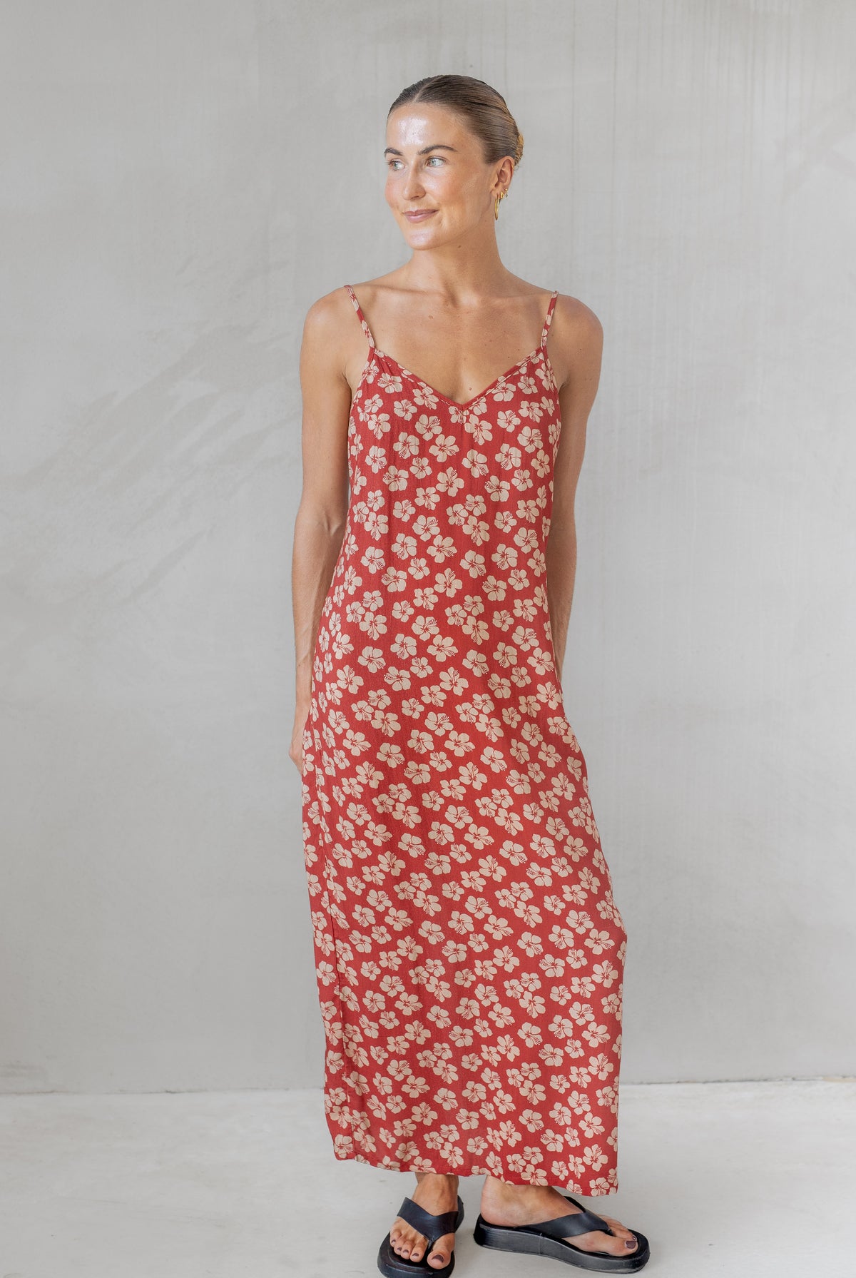 Woman wearing a red floral dress against a plain background
