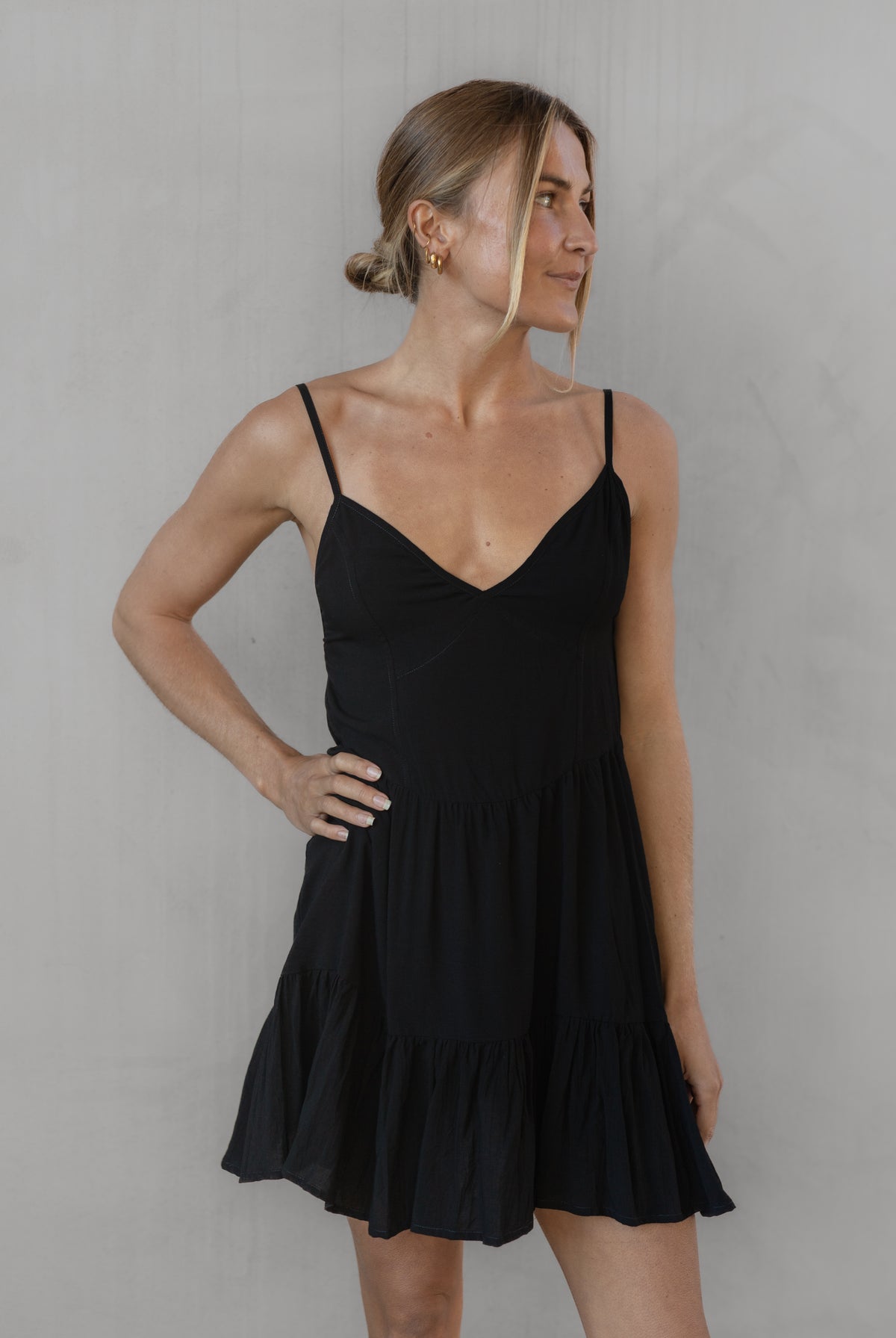 Woman wearing a black dress against a plain background