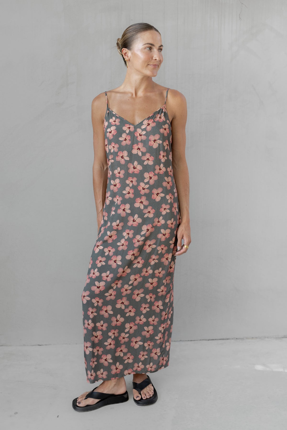 Woman wearing a floral slip dress against a plain background