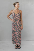Woman wearing a floral dress against a plain background