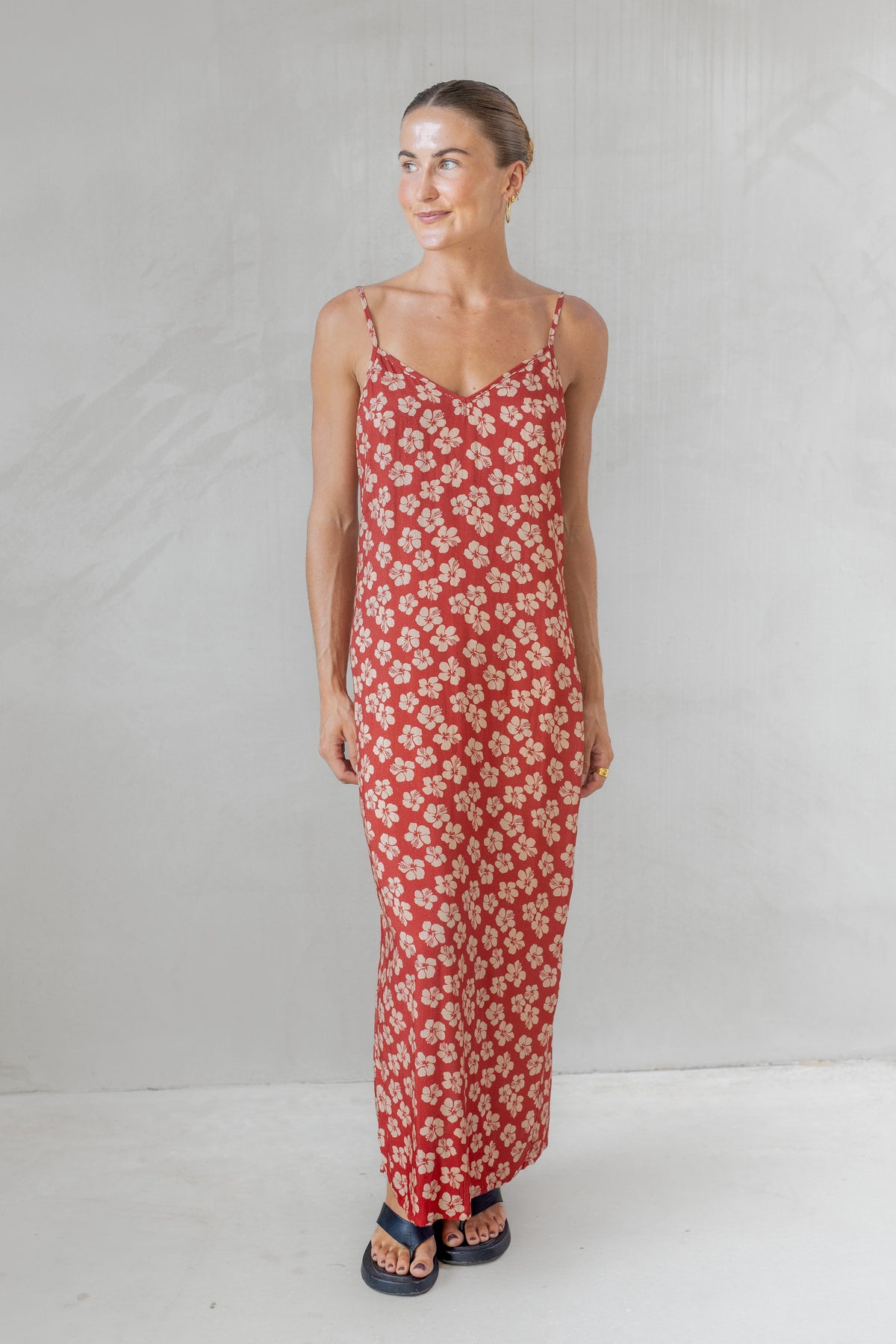 Woman wearing a red floral dress against a white background