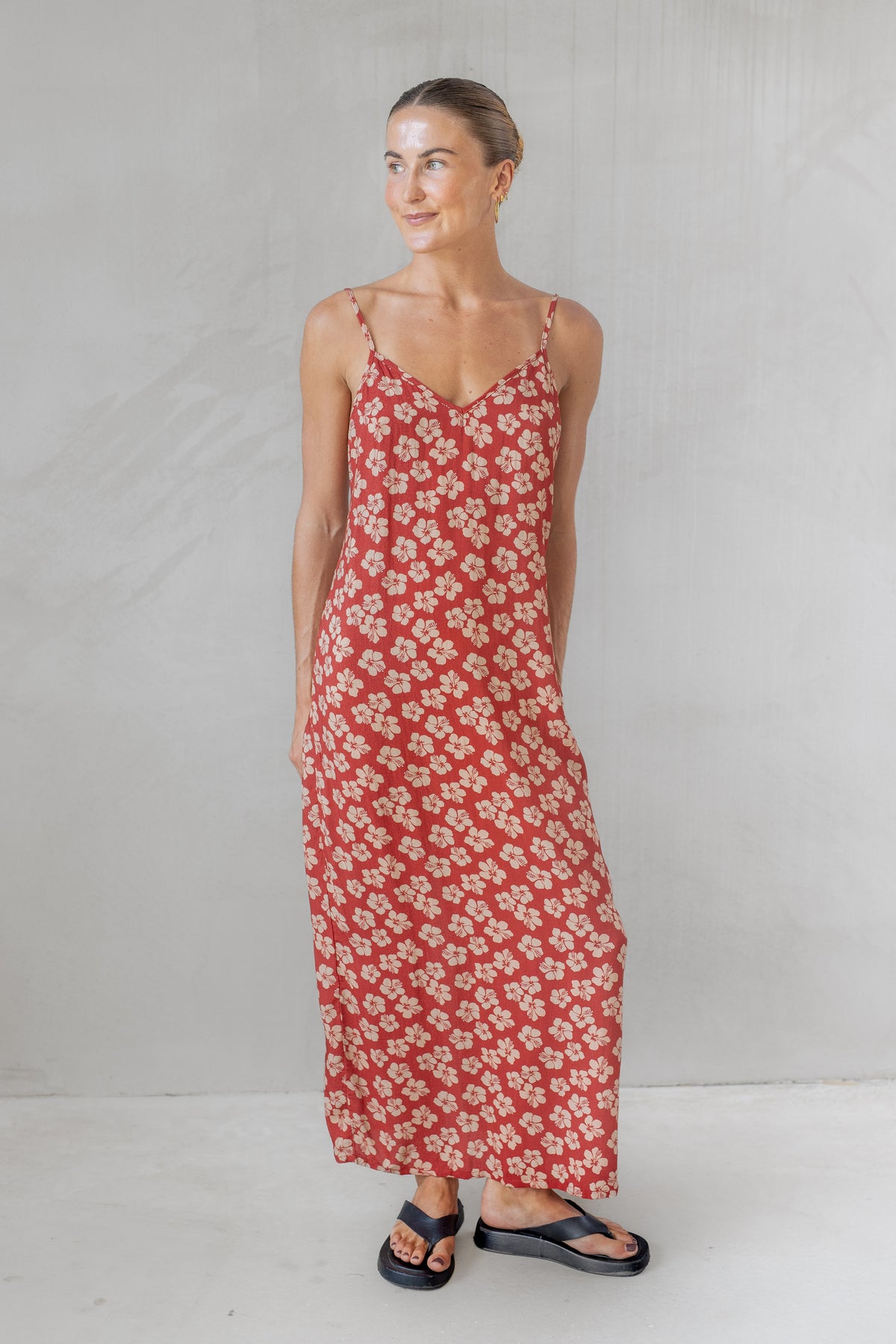 Woman wearing a red floral dress against a plain background