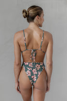 Woman wearing a floral bikini against a plain background
